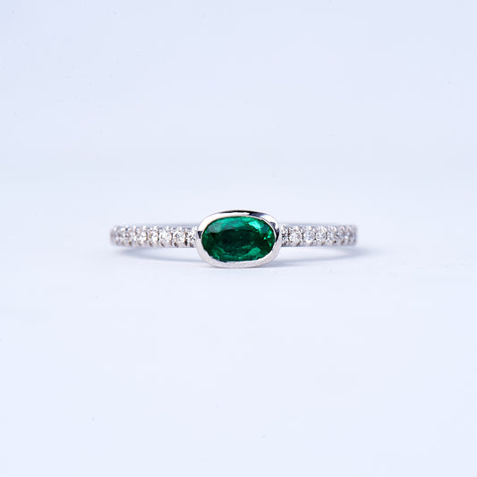 A 14K white gold emerald and diamond ring with a .35CT emerald centerstone and round brilliant diamonds set in an open band design.