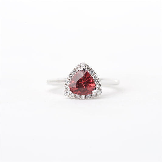 An 18K rare red spinel and diamond ring with a white gold band, highlighted by a central red spinel gemstone surrounded by smaller round brilliant diamonds in a halo setting.