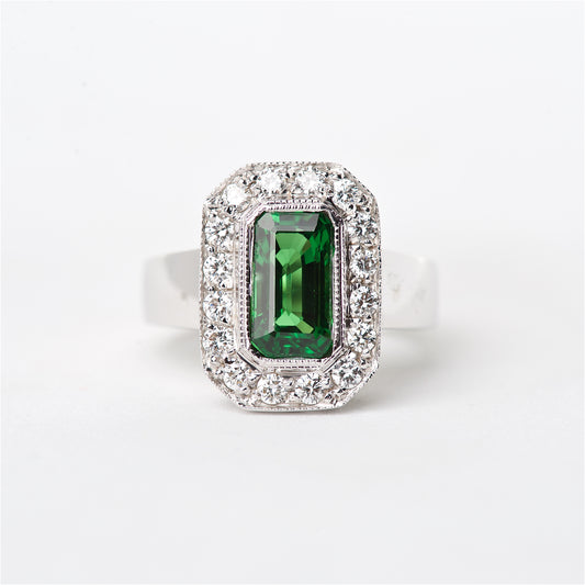 An 18K white gold ring featuring a one of a kind square-cut Tsavorite gemstone surrounded by round brilliant cut diamonds.